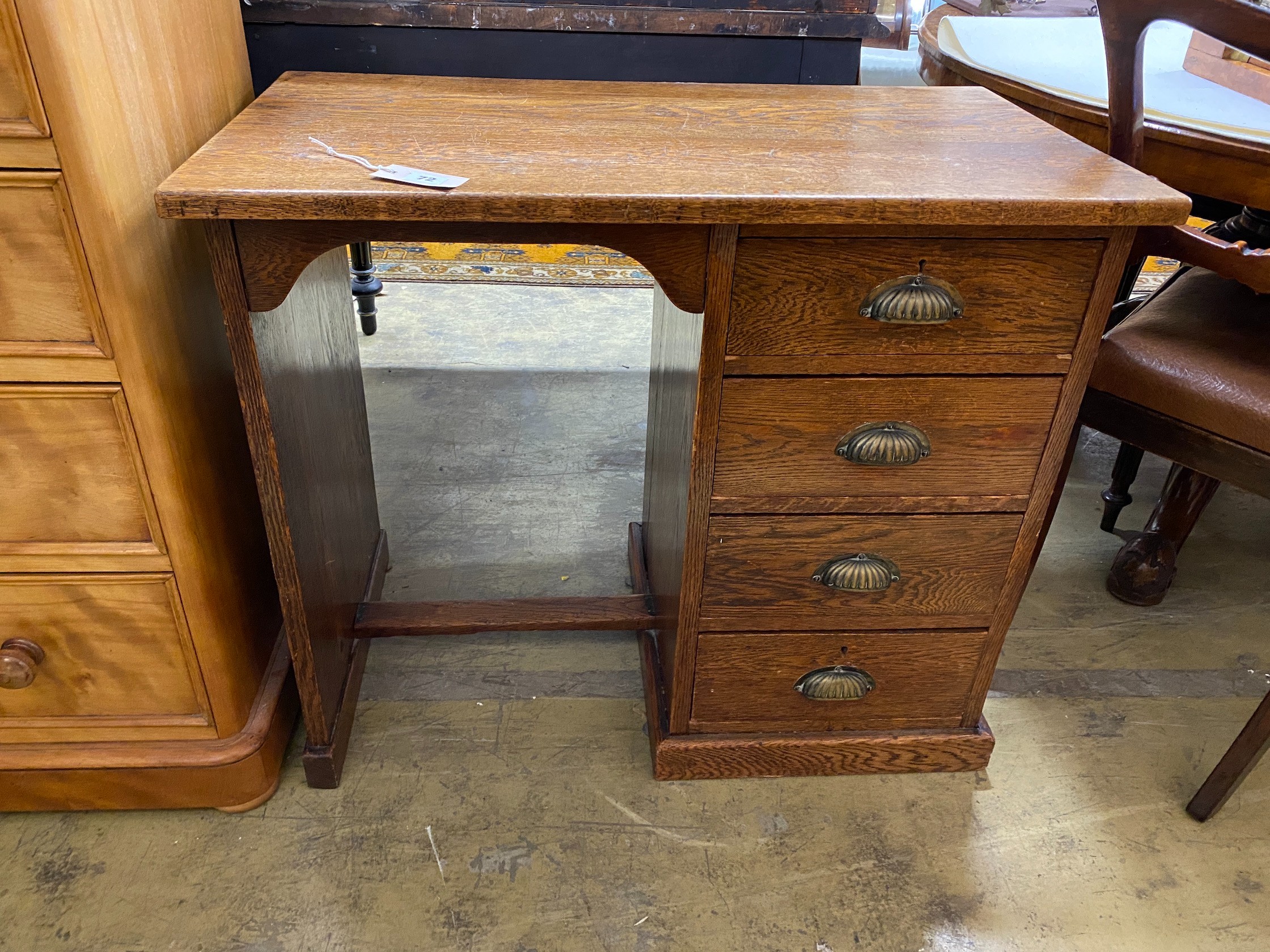 A small 1920's oak four drawer kneehole desk, length 81cm, depth 45cm, height 69cm